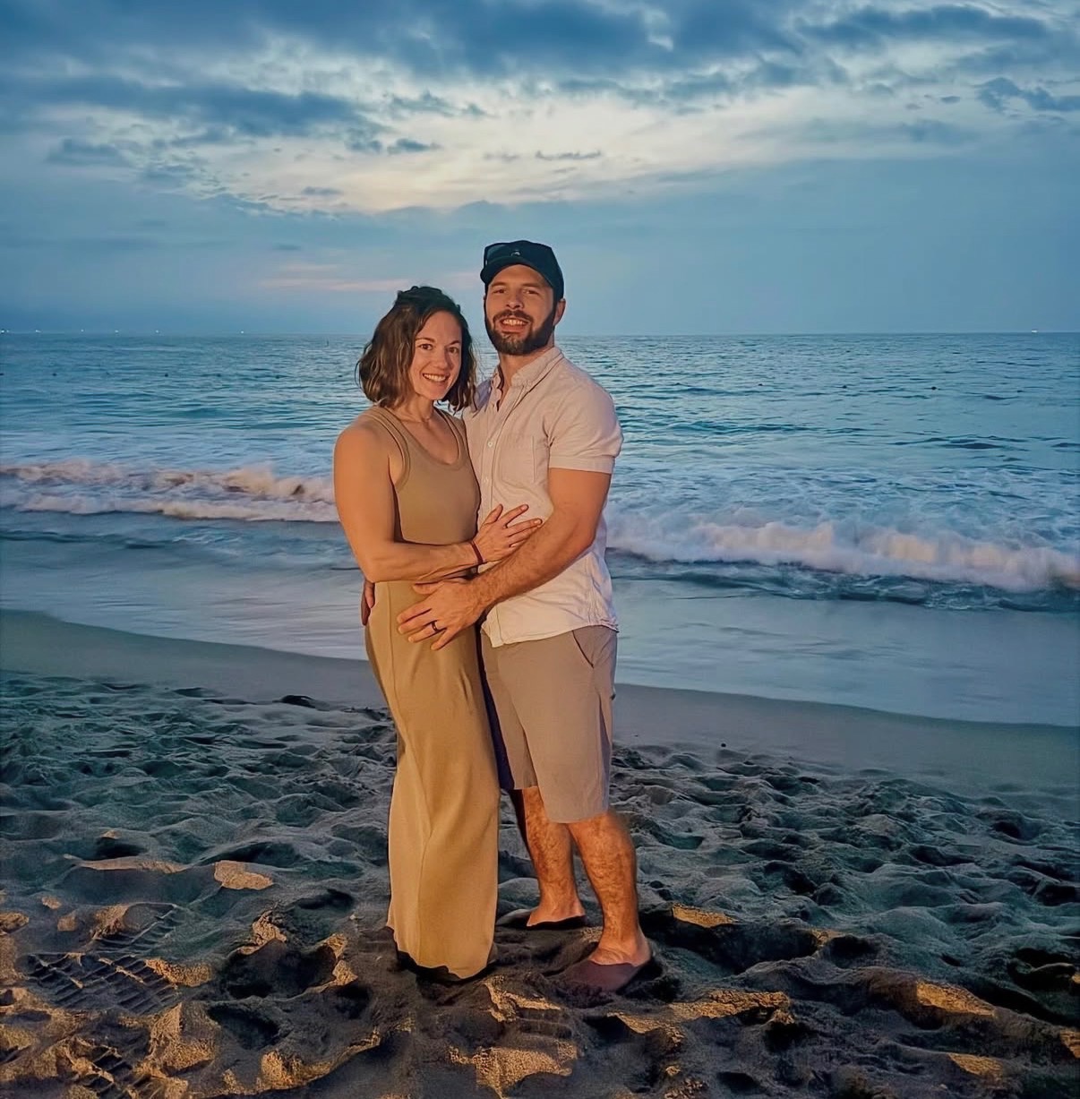 Hannah and Zach together on a beach at sunset